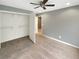 Bedroom features a ceiling fan, closet with shelves, and neutral paint and carpet at 1615 Cheshire Ct, Lawrenceville, GA 30043