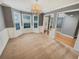 Bright dining room featuring large windows, paneled walls, plush carpeting, and a stylish chandelier at 1615 Cheshire Ct, Lawrenceville, GA 30043