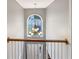 Stairwell chandelier illuminates the upstairs hallway, showcasing a large arched window and railing in a well-lit home at 1615 Cheshire Ct, Lawrenceville, GA 30043