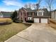 Handsome brick home with two-car garage, manicured shrubs, and a concrete driveway at 1615 Cheshire Ct, Lawrenceville, GA 30043