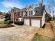 Brick home showcasing an attached two-car garage and manicured front landscaping at 1615 Cheshire Ct, Lawrenceville, GA 30043