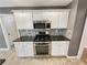 Modern kitchen with white cabinets, stainless steel appliances, and gas range at 1615 Cheshire Ct, Lawrenceville, GA 30043