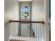 Upstairs landing with a decorative chandelier, bright window, and a view down to the front door at 1615 Cheshire Ct, Lawrenceville, GA 30043