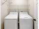 Bright laundry room featuring a white washer, dryer, and wire shelving at 1615 Cheshire Ct, Lawrenceville, GA 30043