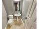 Small powder room features pedestal sink, toilet, mirror and tile floors at 1615 Cheshire Ct, Lawrenceville, GA 30043