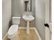 Half bathroom includes pedestal sink, toilet, mirror, and natural stone flooring at 1615 Cheshire Ct, Lawrenceville, GA 30043