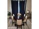 Elegant dining room with an oval table, upholstered chairs, and dark blue curtains at 958 Fellowship Rd, Fairburn, GA 30213