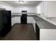 Bright kitchen featuring white cabinets, black appliances, and plenty of counter space at 5942 Rock Court #5, Union City, GA 30291