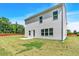 A lovely view of the backyard, the green space beyond the house and the home's neutral siding at 3270 Forest Green Dr, Douglasville, GA 30135