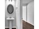 Bathroom featuring a pedestal sink, oval mirror and a view of the hallway and doorway at 3270 Forest Green Dr, Douglasville, GA 30135