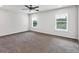 A large bedroom with gray carpet, neutral walls, two windows, and a ceiling fan with an integrated light at 3270 Forest Green Dr, Douglasville, GA 30135