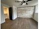 Bedroom with exposed brick wall and dark wood-look tile floors at 1134 Donnelly Sw Ave, Atlanta, GA 30310