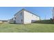 Back exterior view of the house featuring gray siding, well-kept lawn, and patio at 24 Dew Lake Ct, Grayson, GA 30017