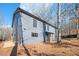 Gray two-story house with wood accents, nestled on a wooded lot at 600 Jones Rd, Roswell, GA 30075