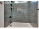 Clean bathroom with grey tile shower/tub combo and built-in shelves at 884 Derrydown Way, Decatur, GA 30030