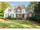 Charming two-story home features a welcoming front porch, brick accents, and lush landscaping at 6234 Creekstone Path, Cumming, GA 30041