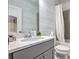 Stylish bathroom with light blue textured walls, a gray vanity, and a shower-tub combination with a white curtain at 2341 Brissett Ln, Brookhaven, GA 30319