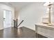 Upstairs landing area featuring dark wood floors, white walls, a decorative table, and doorway leading to the bedroom at 2341 Brissett Ln, Brookhaven, GA 30319