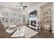 Elegant living room featuring a cozy fireplace, dark hardwood floors, and bright windows with plantation shutters at 2341 Brissett Ln, Brookhaven, GA 30319