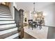 Staircase leading to a dining area, showcasing dark wood floors, and a stylish chandelier at 2341 Brissett Ln, Brookhaven, GA 30319