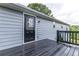 A view of the back deck with black painted deck and a glass paneled door at 3950 Yancey Rd, Douglasville, GA 30135