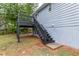 Back of the house with stairs leading to a black painted deck at 3950 Yancey Rd, Douglasville, GA 30135