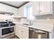 Close up of stove in kitchen featuring stainless steel appliances and white cabinets at 3950 Yancey Rd, Douglasville, GA 30135