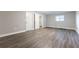 Large empty room featuring gray walls, modern floors, white trim and side door at 3950 Yancey Rd, Douglasville, GA 30135