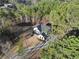 Bird's eye view of a farmhouse style home nestled among tall trees, featuring a modern design and long driveway at 3785 Pilgrim Mill Rd, Cumming, GA 30041