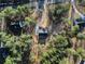 Aerial view of a secluded home with a black roof and long driveway surrounded by lush greenery and trees at 3785 Pilgrim Mill Rd, Cumming, GA 30041