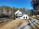 Aerial shot of white modern farmhouse, landscaping, and driveway at 3785 Pilgrim Mill Rd, Cumming, GA 30041