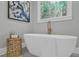 Bathroom featuring a soaking tub, a golden stool and a window overlooking the trees at 3785 Pilgrim Mill Rd, Cumming, GA 30041