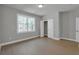 This bedroom features light hardwood flooring, a large window, and neutral colored walls at 3785 Pilgrim Mill Rd, Cumming, GA 30041