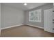 This bedroom features light hardwood flooring, a large window, and neutral colored walls at 3785 Pilgrim Mill Rd, Cumming, GA 30041