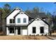 Modern farmhouse exterior with white siding, black trim, and manicured front lawn at 3785 Pilgrim Mill Rd, Cumming, GA 30041