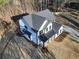 Aerial view of a farmhouse-style home featuring a modern design and a long driveway amid a spacious, wooded lot at 3785 Pilgrim Mill Rd, Cumming, GA 30041