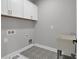 Well-organized laundry room with storage cabinets, utility sink, and stylish patterned floors for added functionality at 3785 Pilgrim Mill Rd, Cumming, GA 30041