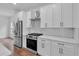 Modern kitchen with white cabinets, stainless steel appliances, and herringbone backsplash at 42 Puckett Se Rd, Emerson, GA 30137