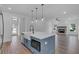 Open concept kitchen with blue island, white cabinets, and farmhouse sink, overlooking living room at 42 Puckett Se Rd, Emerson, GA 30137