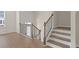 Modern staircase with dark metal railing and hardwood steps at 314 Cornett Way, Lawrenceville, GA 30046