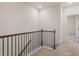 Upstairs hallway with a metal railing and carpet flooring at 314 Cornett Way, Lawrenceville, GA 30046