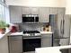 Kitchen with gray cabinetry, stainless steel appliances, and a herringbone backsplash at 2479 Peachtree Ne Rd # 105, Atlanta, GA 30305