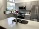 Kitchen with gray cabinetry, stainless steel appliances, and a herringbone backsplash at 2479 Peachtree Ne Rd # 105, Atlanta, GA 30305