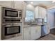 White kitchen cabinets, granite counters and stainless steel appliances at 1204 Westridge Sw Rd, Atlanta, GA 30311