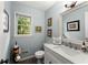 Light blue bathroom with framed art, white towels in decorative bin, and dark flooring at 4250 Edgewater Nw Ct, Kennesaw, GA 30144