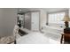 Bright bathroom features a tub with a view, white tile floors, and a neutral color palette at 4250 Edgewater Nw Ct, Kennesaw, GA 30144