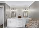 Bathroom with double sinks, marble countertop, modern lighting, and decorative mirrors at 4250 Edgewater Nw Ct, Kennesaw, GA 30144