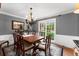 Dining room with a wood table, chandelier, and view to the landscaped outdoors at 4250 Edgewater Nw Ct, Kennesaw, GA 30144