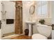 Cozy bathroom with a pedestal sink, tiled shower, and a window for natural light at 1045 N Main Nw St, Conyers, GA 30012