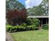A view of the home's front yard, featuring a mix of lush greenery and mature shade trees at 1685 Dogwood Trl, Douglasville, GA 30134